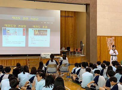 태권도 진로체험 프로그램. 강당에서 학생들과 프로젝터로 학습자료 함께 공부