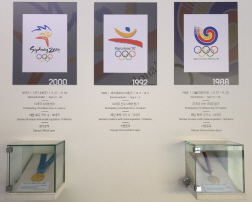 [크기변환]사진 1 1988년 서울올림픽 태권도 금메달(시범종목)과 2000년 시드니올림픽 금메달(정식종목)(국립태권도박물관 내 기증품).jpg