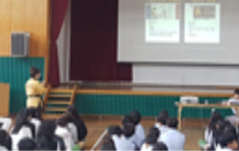 교육기부 진로체험 실행 장면. 강사의 지도하에 강당에서 체조 등 수련