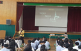 교육기부 진로체험 실행 장면. 강사의 지도하에 강당에서 체조 등 수련